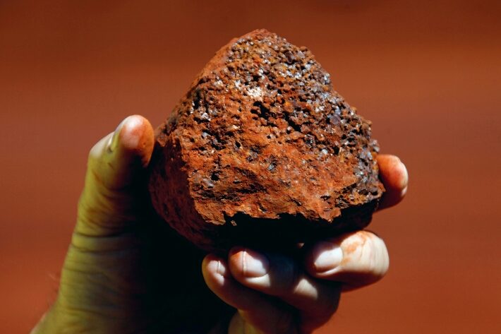 Um pedaço de minério de ferro nas mãos de um mineiro. Foto: David Gray/ Reuters