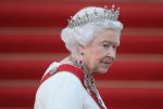 a imagem mostra a Rainha Elizabeth II, ao fundo há escadas em vermelho.