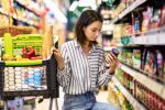 a imagem mostra uma mulher olhando produtos no mercado. a imagem faz alusão a alta de preços nos alimentos e como as marcas próprias dos supermercados pode ser atrativo na economia