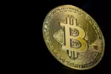 Imagem mostra moeda de ouro que representa o bitcoin.