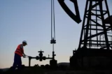 Trabalhador opera válvula em estação de extração de petróleo