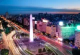 Vista aérea de Buenos Aires à noite com Obelisco e carros passando pela avenida 9 de Julio