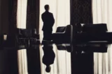 Homem solitário diante da janela em uma sala luxuosa