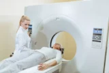 Técnico medico feminino e paciente sênior durante procedimento de tomografia computadorizada