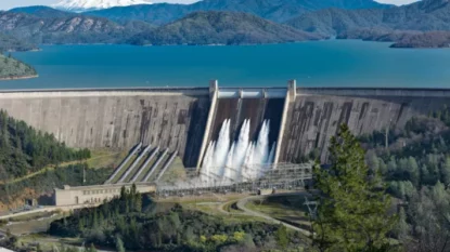 Imagem mostra panorâmica de barragem hidrelétrica em dia ensolarado.