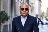 Retrato de executivo na rua, vestindo terno e óculos escuros