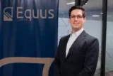 Imagem mostra o executivo Felipe Vasconcellos, da Equus, em pose na frente de banner da companhia. (Imagem: Equus)