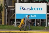 Imagem mostra dois trabalhadores andando em frente à petroquímica Braskem (BRKM5).
