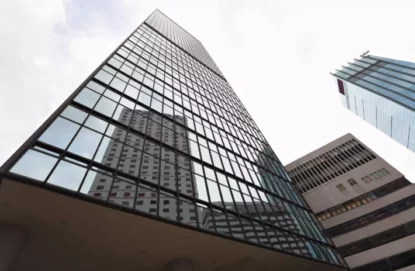 Imagem mostra edifícios comerciais de fachada espelhada vistas da rua.