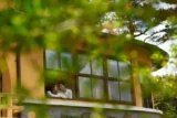 Casal se abraça em janela de residência.