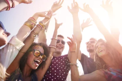 Foto mostra grupo de jovens em comemoração durante um dia de sol.