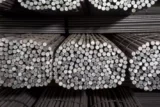 Imagem mostra tubos de aço empilhados.