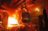 Produção de aço em fornos elétricos dentro de fábrica metalúrgica.