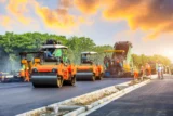 Canteiro de obras para colocação de novo pavimento de asfalto. Imagem mostra trabalhadores de construção de estradas e máquinas de construção de rodovias.
