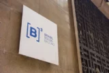 Imagem mostra placa da B3 em uma parede.