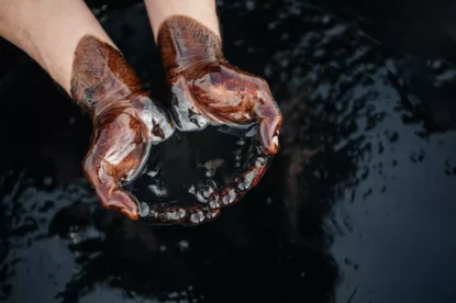 Imagem mostra mãos em cuia cheias de petróleo.