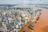 Imagem mostra vista aérea de Porto Alegre inundada por enchentes.