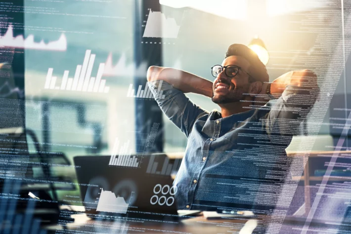 Imagem mostra arte representativa do mercado financeiro com homem sorrindo de satisfação com as mãos apoiadas na cabeça ao fundo.