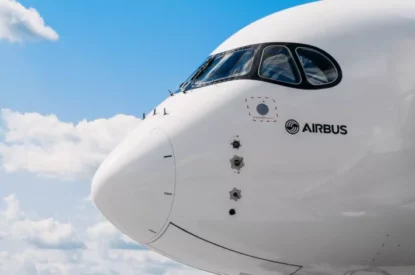 Vista externa da cabine de aeronave da Airbus sob céu azul com nuvens esparças.