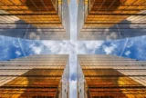 Vista de baixo para cima de arranha-céus espelhados em metrópole, com reflexo de nuvens entre edifícios altos, vidros de construção, negócios e finanças.