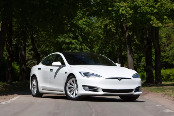 Carro elétrico Tesla Model S 2022 em estrada rural em um lindo dia de sol. Montadora pertence ao bilionário Elon Musk.