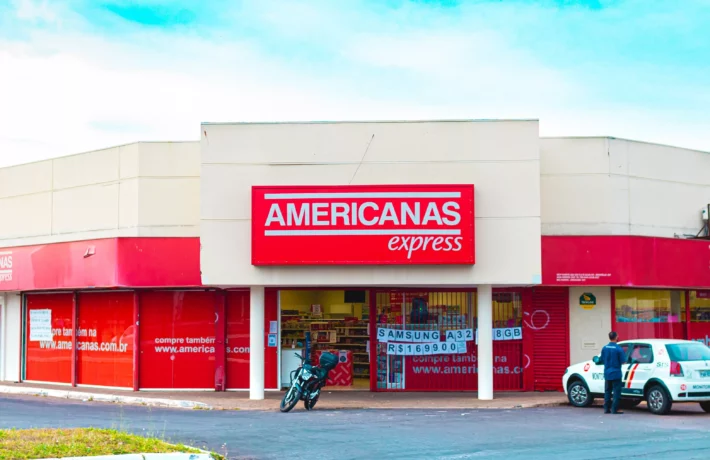 Fachada de loja da Americanas sob céu azu.