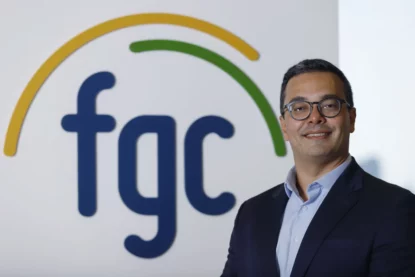 Retrato de executivo de terno e óculos ao lado da logo do FGC.