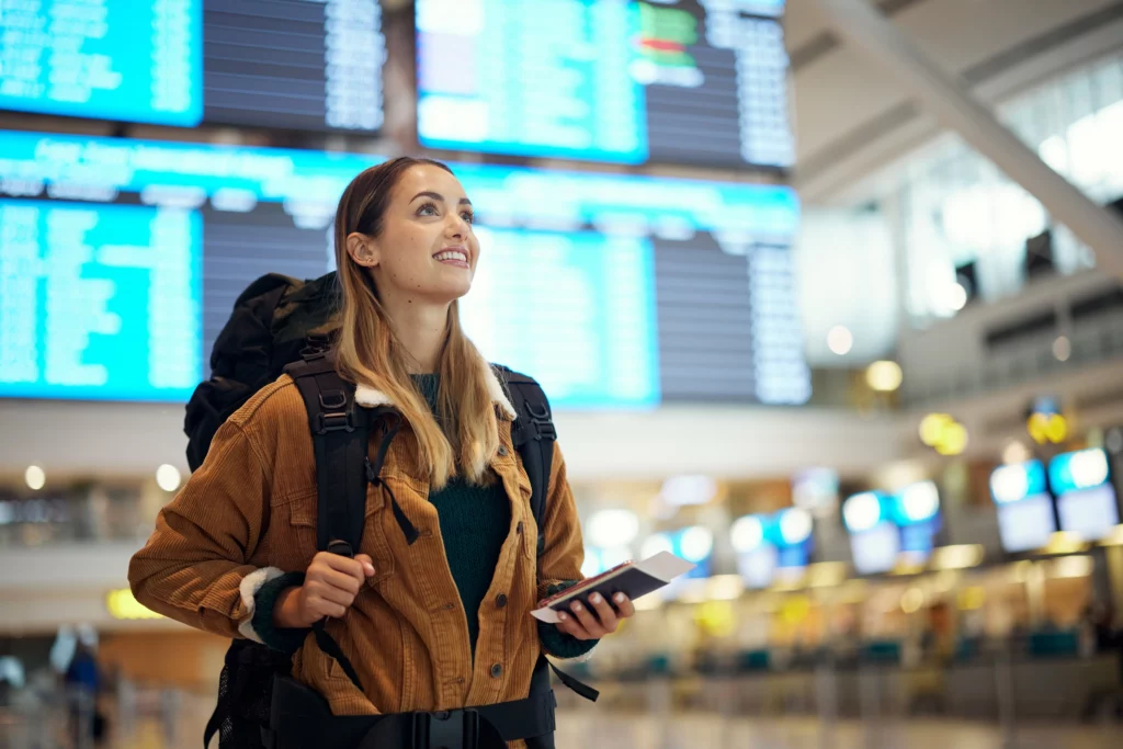 Viagens, aeroporto e mulher animada com passaporte. Bilhete de viagem e documentos para morar fora.