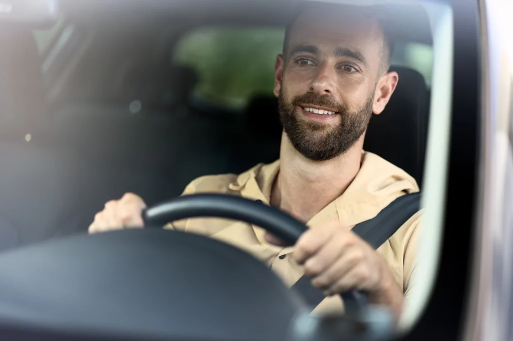 Homem dirigindo um carro na estrada com cinto de segurança