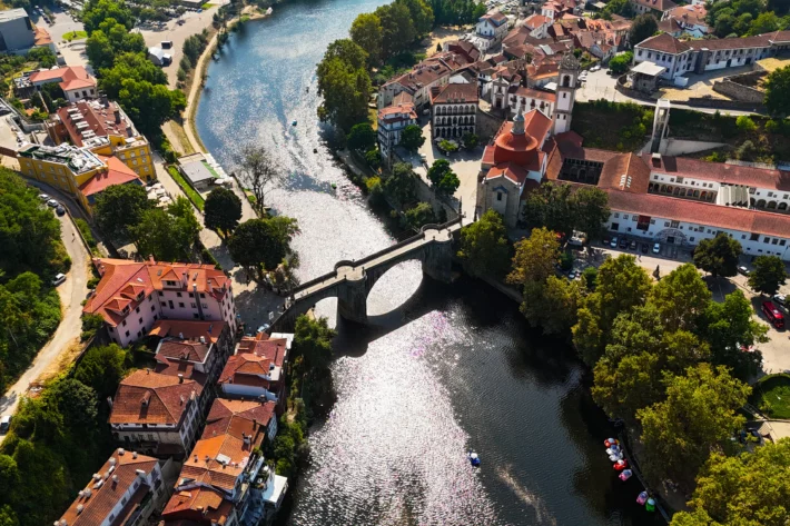 Brasileiros em Portugal podem gastar mais por desconhecer regras de aluguel, energia, transporte e consumo. Veja erros comuns e como evitar custos extras no in&iacute;cio da adapta&ccedil;&atilde;o. | Imagem a&eacute;rea de Amarante, em Portugal, via Adobe Stock.