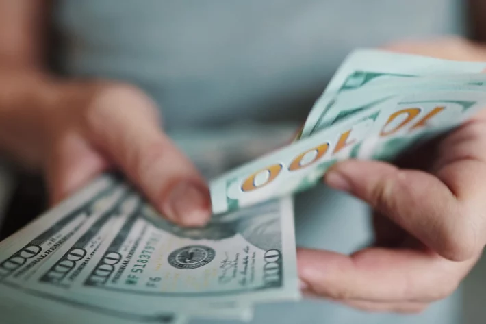 D&oacute;lar hoje avan&ccedil;a com petr&oacute;leo acima de US$ 100 e escalada no Oriente M&eacute;dio. IPCA-15 pressionado e sinaliza&ccedil;&atilde;o do BC sobre juros altos refor&ccedil;am a alta da moeda. (Imagem: Adobe Stock) 