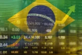Gráficos financeiros com a bandeira do Brasil ao fundo. Mesmo com potencial de alta, Ibovespa levanta dúvidas sobre risco e tempo de retorno frente aos juros elevados no Brasil. (Imagem: Adobe Stock)