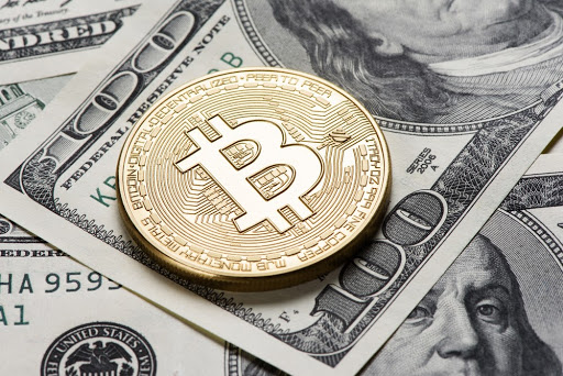 Moeda de bitcoin em cima de cédula de dólar