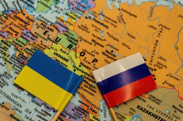 Bandeiras da Ucrânia e Rússia em cima do mapa da Europa